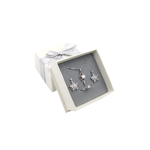 White gift box with silver ribbon containing snowflake earrings necklace and ring set