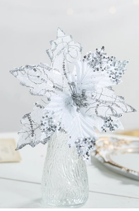 Détail d'une fleur de poinsettia argentée artificielle avec paillettes dans un vase