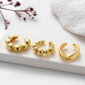 Three minimalist gold-plated ear cuffs set with beaded and smooth textures for non-pierced ears