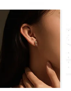 Macro shot of silver slipper-shaped stud earrings with colorful inset gemstones