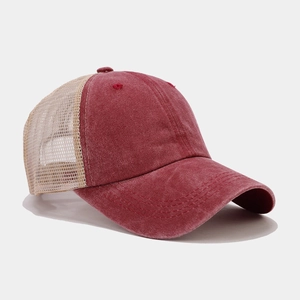 Detail of washed red trucker hat showing vintage cotton fabric and breathable brown mesh