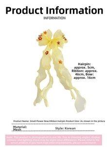 Detail of yellow mesh bow hair clip with floral accents and 46cm long wavy streamers