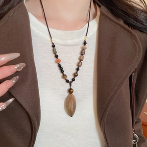 Detailed close-up of beaded necklace with tiger eye stone and natural pendant charm