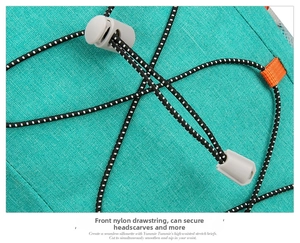 Detail van groenblauwe fietsrugzak met elastisch bungeekoord, grijze stopper en oranje band
