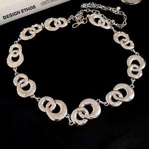 Macro detail of interlocking silver metal rings with white crystal rhinestones and clasp