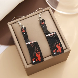 Detail view of Halloween cleaver earrings with realistic red blood splatters on black base