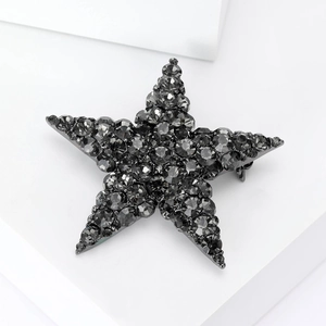 Close-up of a gunmetal star brooch featuring brilliant dark grey crystal pavé detailing