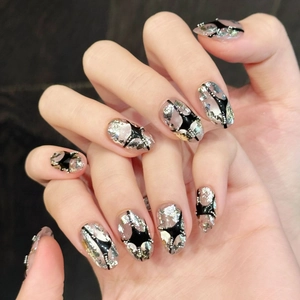 Hand-painted cat-eye press-on nails with silver glitter, black star lines and tiny pearls