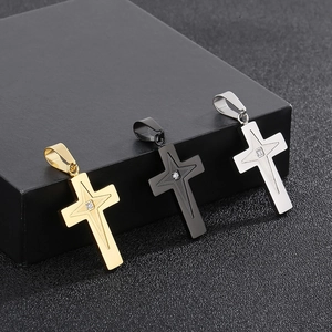 Detailed view of three stainless steel cross pendants in gold, black, and silver finishes