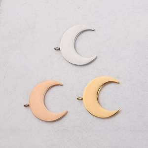 Detailed view of polished crescent moon pendants in silver, gold, and rose gold finishes
