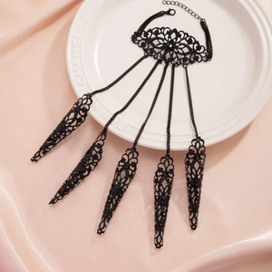 Bracciale gotico in pizzo metallico nero con anelli ad artiglio su vassoio bianco
