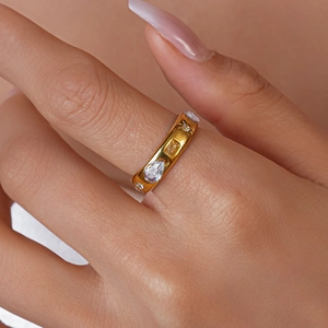 Macro view of gold stainless steel ring featuring sunburst and teardrop zircon inlays