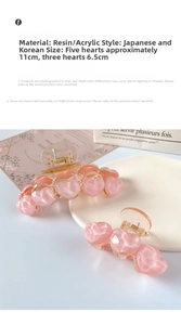 Detail showing pink heart hair claws in 11cm and 6.5cm sizes with golden spring