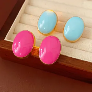 Vintage gold-trimmed oval stud earrings in sky blue and bright pink in jewelry box
