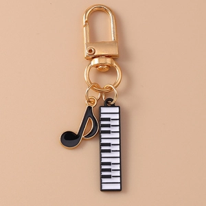 Detailed view of music themed keychain with enamel piano keys and gold note pendant