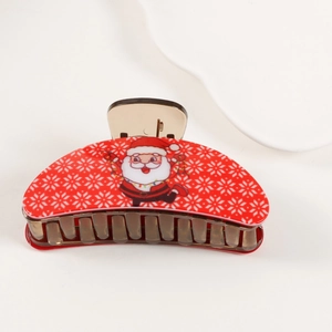 Detail of red Christmas hair claw clip with snowflake pattern and Santa Claus motif