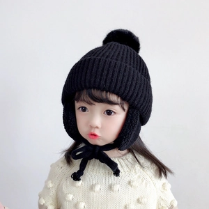 Warm black knitted trapper hat for kids with large faux fur pompom and earflaps
