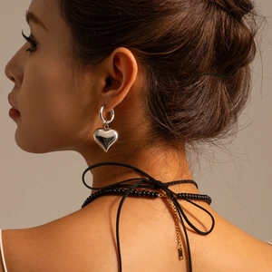 Polished silver heart pendant earrings shown on model for a modern minimalist style