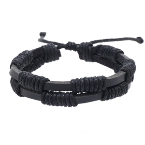 Detail showing hand-woven black leather cord bracelet with adjustable knot closure
