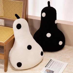 Plush pear shaped polka dot throw pillows in black and white set on a cozy rug
