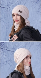 Dettaglio del set cappello e scaldacollo in maglia crema con toppa in pelle di montagna