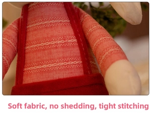 Detail of red knit fabric and tight stitching on a soft plush rabbit toy's outfit