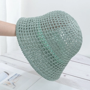 Detailed close-up of light green knit bucket hat showing breathable hollow-out texture