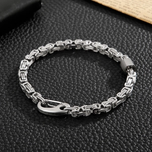 Detail of silver stainless steel Byzantine box chain with unique lobster clasp on leather