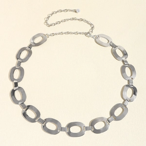 Detail of silver oval link chain belt with adjustable tail and metal ball charm