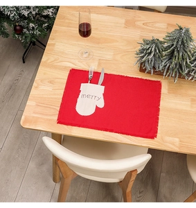 Close-up of red linen Christmas placemat with merry glove pocket for cutlery