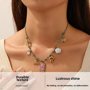 Macro detail of hand-woven colorful rope necklace with diverse vintage golden pendants