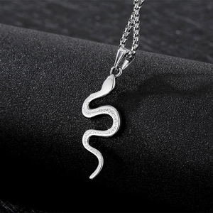 Vintage silver stainless steel snake pendant necklace with box chain on dark stone surface
