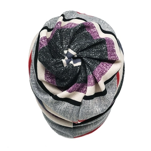 Top view detail of striped knit beanie with unique spiral twist and colorful pattern