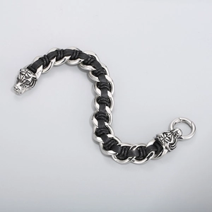 Detailed close-up of tiger head biker bracelet with silver metal and black leather weave