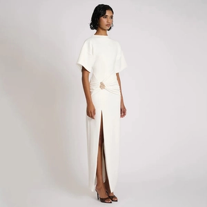 Détail de la robe longue blanche avec boucle dorée et fente latérale haute chic