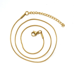 Detailed view of a spiraled gold thin chain necklace with lobster clasp and extension