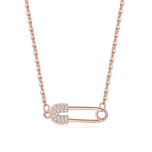 Detail of rose gold safety pin pendant necklace with shimmering zircon stones