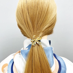 Elegant gold metal floral hair tie with 3D embossed petal texture on a ponytail