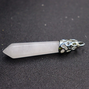 Close-up of white crystal hexagonal pillar pendant with silver metal bail on dark background