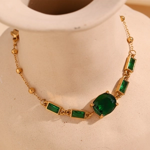 Détail d'un bracelet plaqué or 18 carats avec pierre ovale verte et zircons rectangles