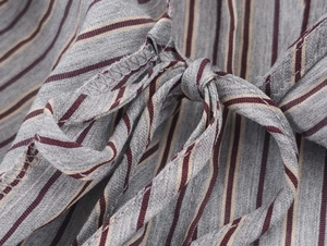 Close-up of gray striped shirt with a red and white bow tie detail and fabric texture