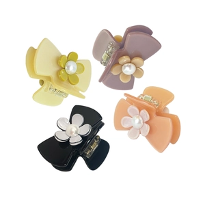 Set of four colorful hair clips in yellow, purple, black, and orange with pearl flower