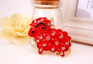 Detail of red rhinestone sheep keychain with gold alloy finish and crystal beads