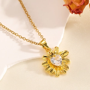 Détail du collier pendentif tournesol avec cristal en forme de cœur sur fond de soie blanche