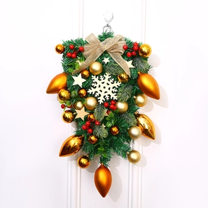 Detailansicht eines festlichen Weihnachts-Swags mit goldenen Ornamenten und Schleife.