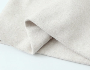 Close-up detail of soft beige wool blend fabric texture for hooded winter coat