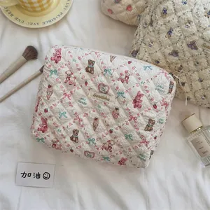 Détail de la trousse matelassée à fleurs avec motifs d'ours et fermeture éclair