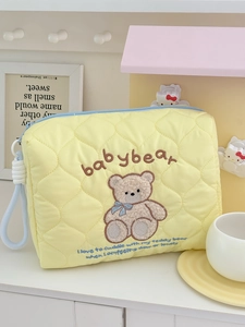 Quilted yellow makeup bag with bear embroidery and blue rope handle for travel