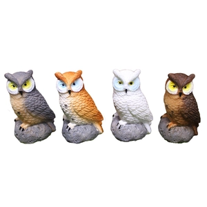 Set of four realistic resin owl figurines in various colors on faux rock bases
