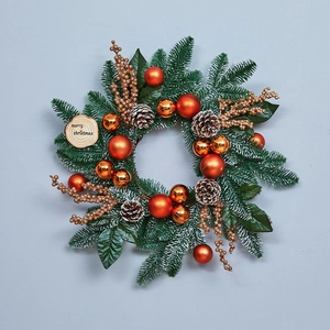 Christmas pine wreath with red gold ornaments and Merry Christmas wooden sign hanging